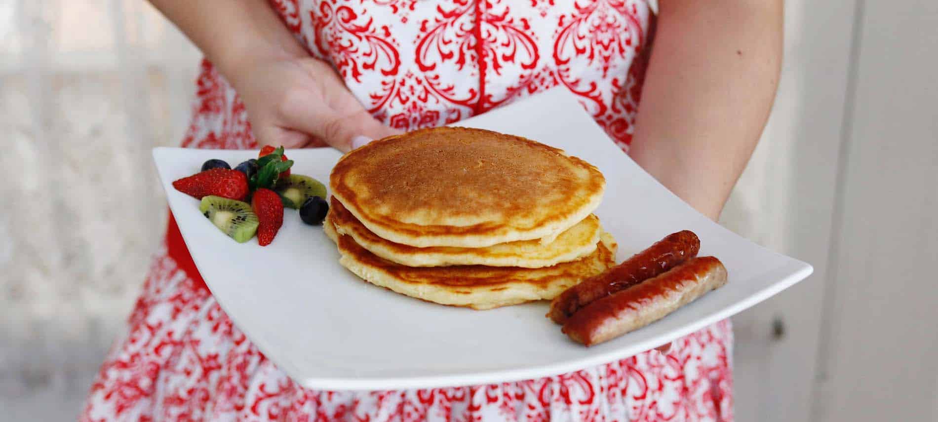 vignette-hands-holding-plate-of-pancake-red-white-apron