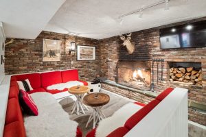 red pit group in front of large fireplace in brick walled room