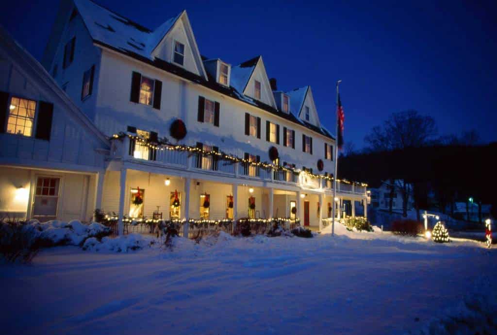 large white hotel draped in garland on a snowy night