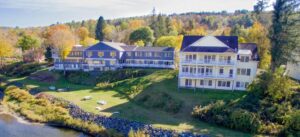 long motel building on a green lawn along a river