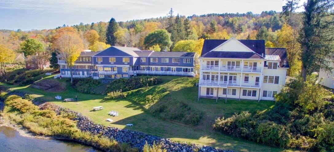 long motel building on a green lawn along a river