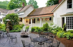 outdoor seating in front of white building with porch