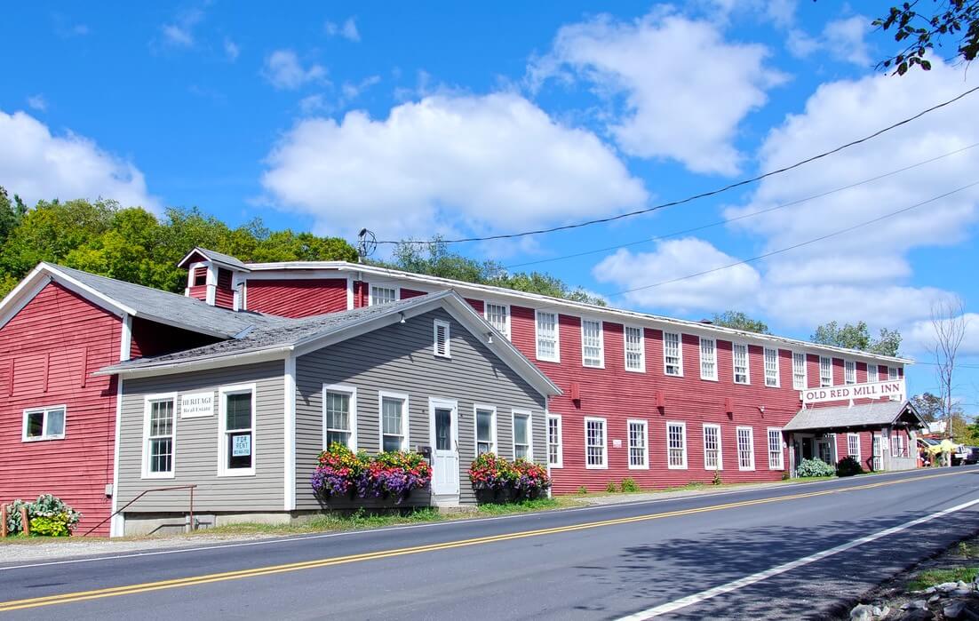 long red mill building on a roadside