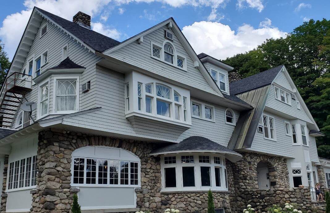 Large gray house with stone foundation