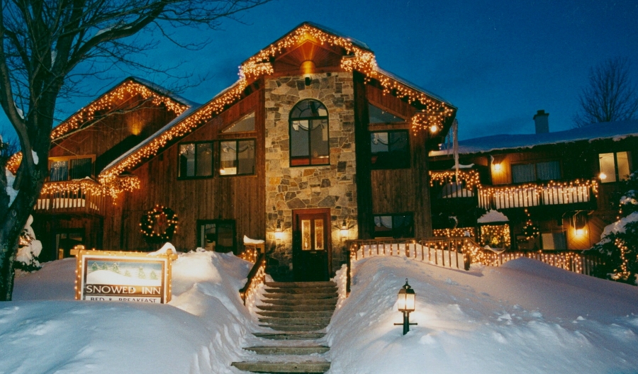 inn with stone entrance, holiday lights, and snow