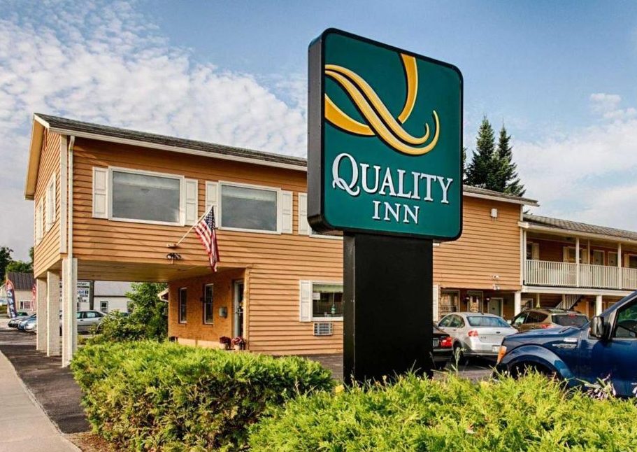 Quality Inn sign in front of building and landscaping