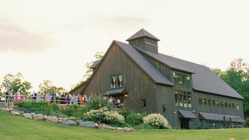 gray building surrounded by flowers on a hillside